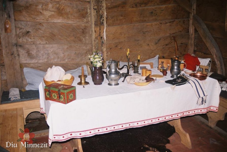 Tisch in der Kammer mit bestickter Decke und Gegenstnden alltglichen Gebrauchs